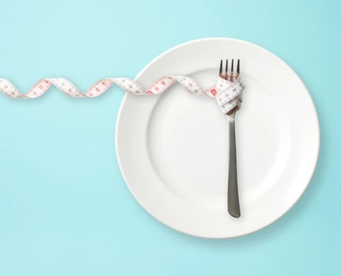 Teller mit Gabel und Maßband Symbolbild Ernährung